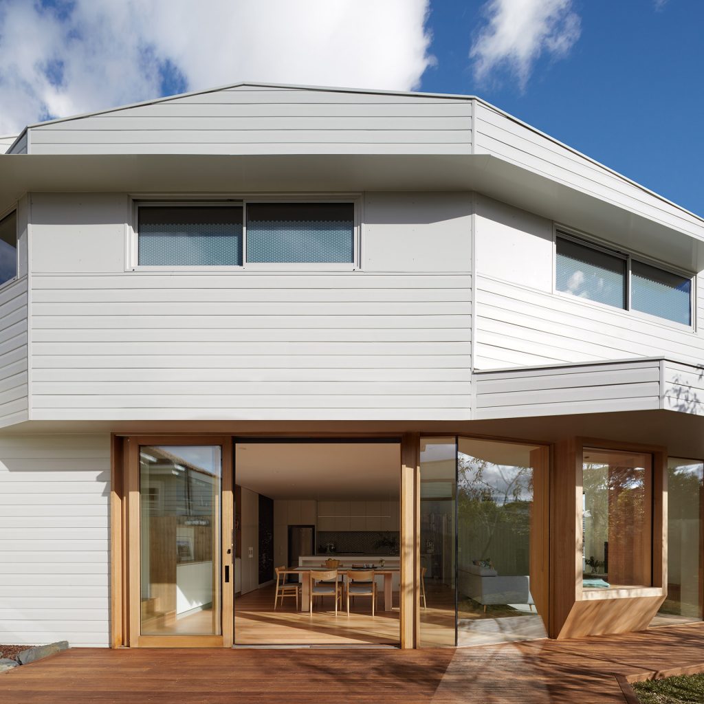 Unusal style home created using Weathertex Primelok Shadowood Smooth 170mm timber cladding with timber trim around doors and timber deck.