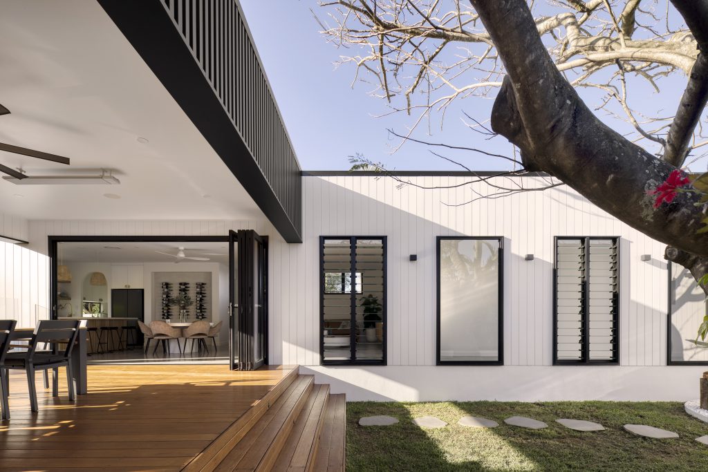 The back of a home in Weathergroove 150 Smooth white outdoor cladding panels with black along the edge of the outdoor area.